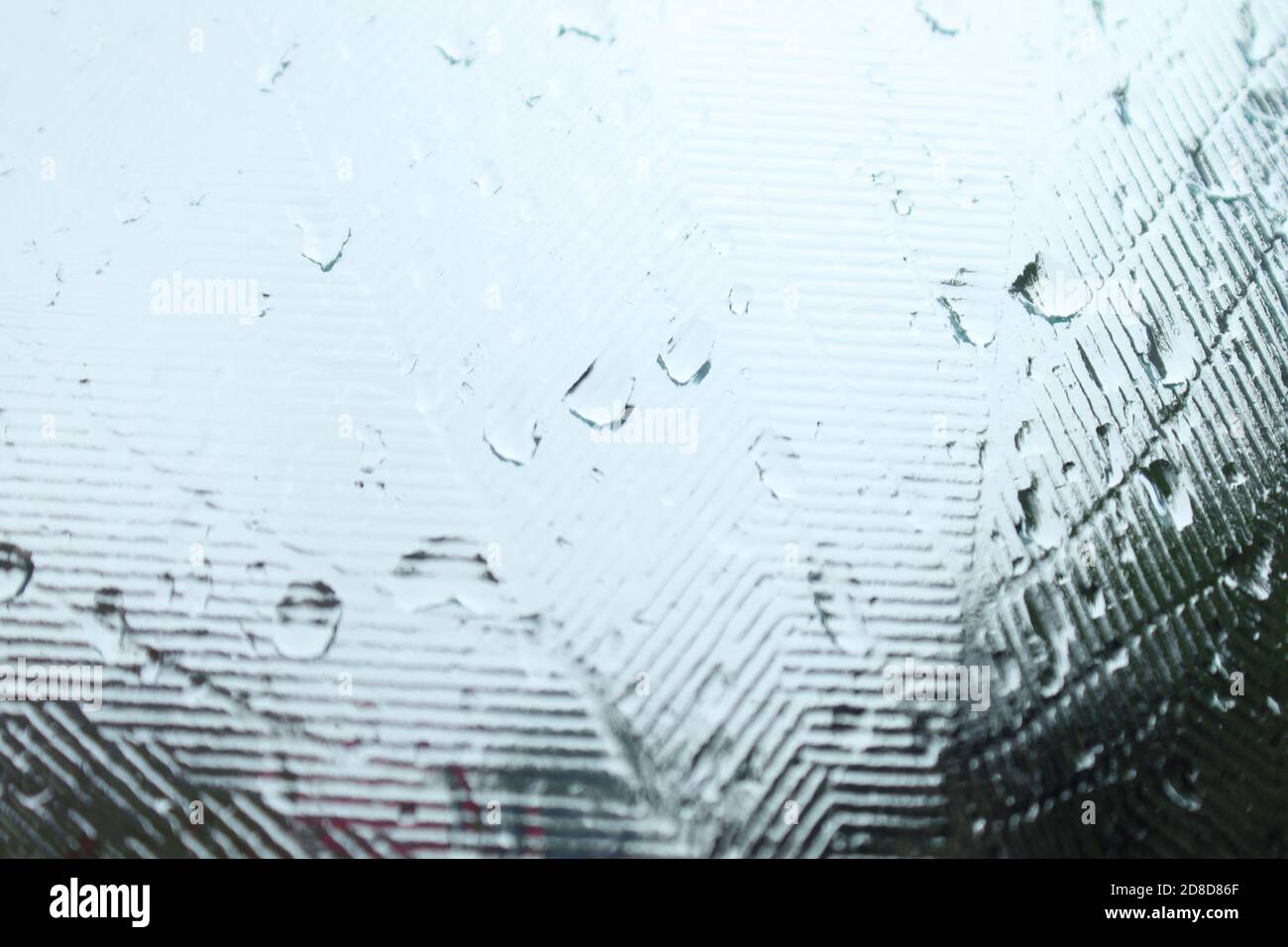 Regenwasser auf einem Milchglasfenster, abstrakte Hintergründe Stockfoto