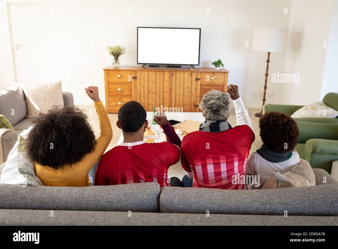 Rückansicht der Multi-Generation-Familie jubelt beim Sport Auf dem Fernseher zu Hause Stockfoto