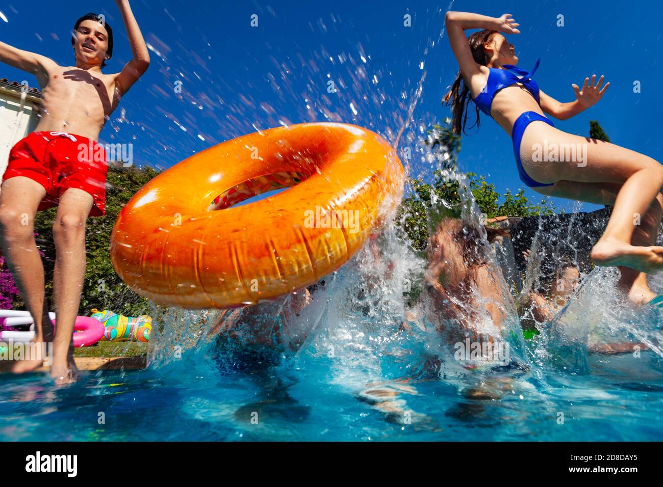 Spaß im Pool eine Gruppe von Teenagern mit Donut springen und