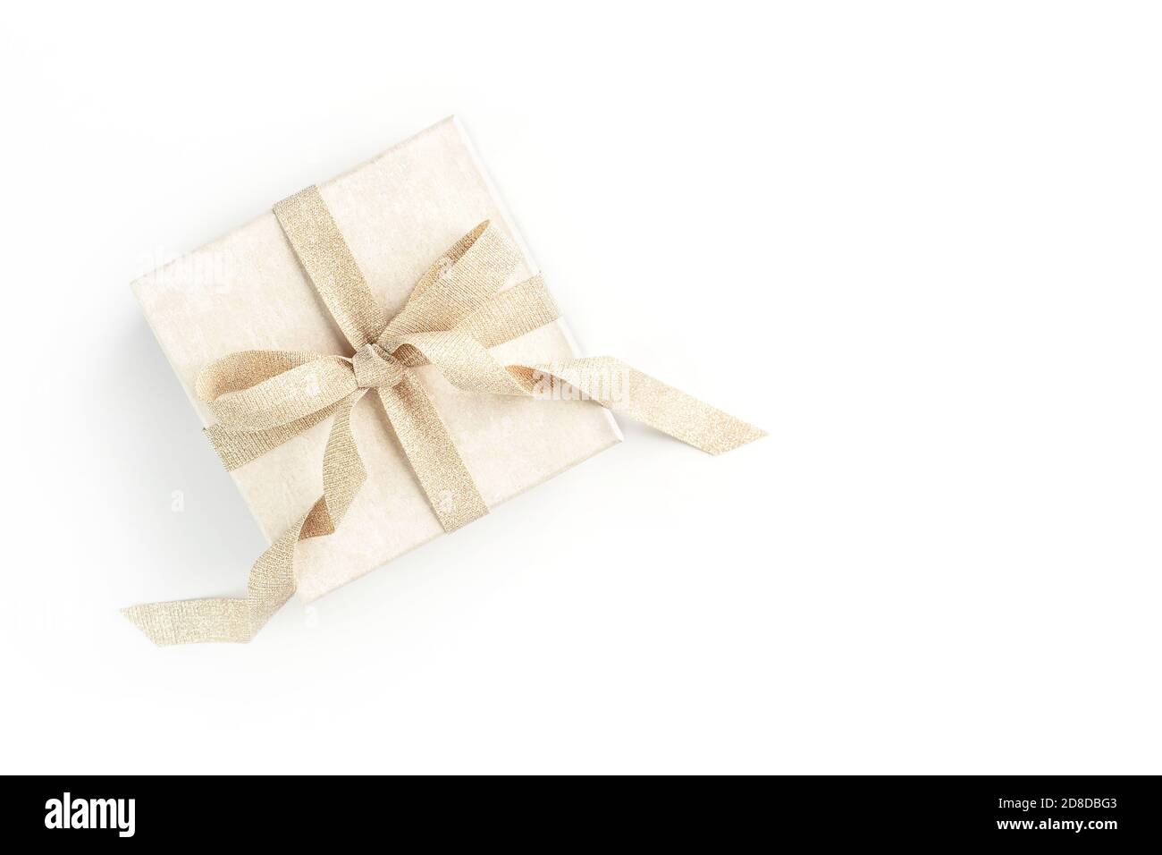 Schöne Geschenk-Box mit eleganten goldenen Schleife auf isoliertem weißem Hintergrund. Festlicher Hintergrund für Ihr Urlaubsdesign. Flache Lay-Optik. Stockfoto