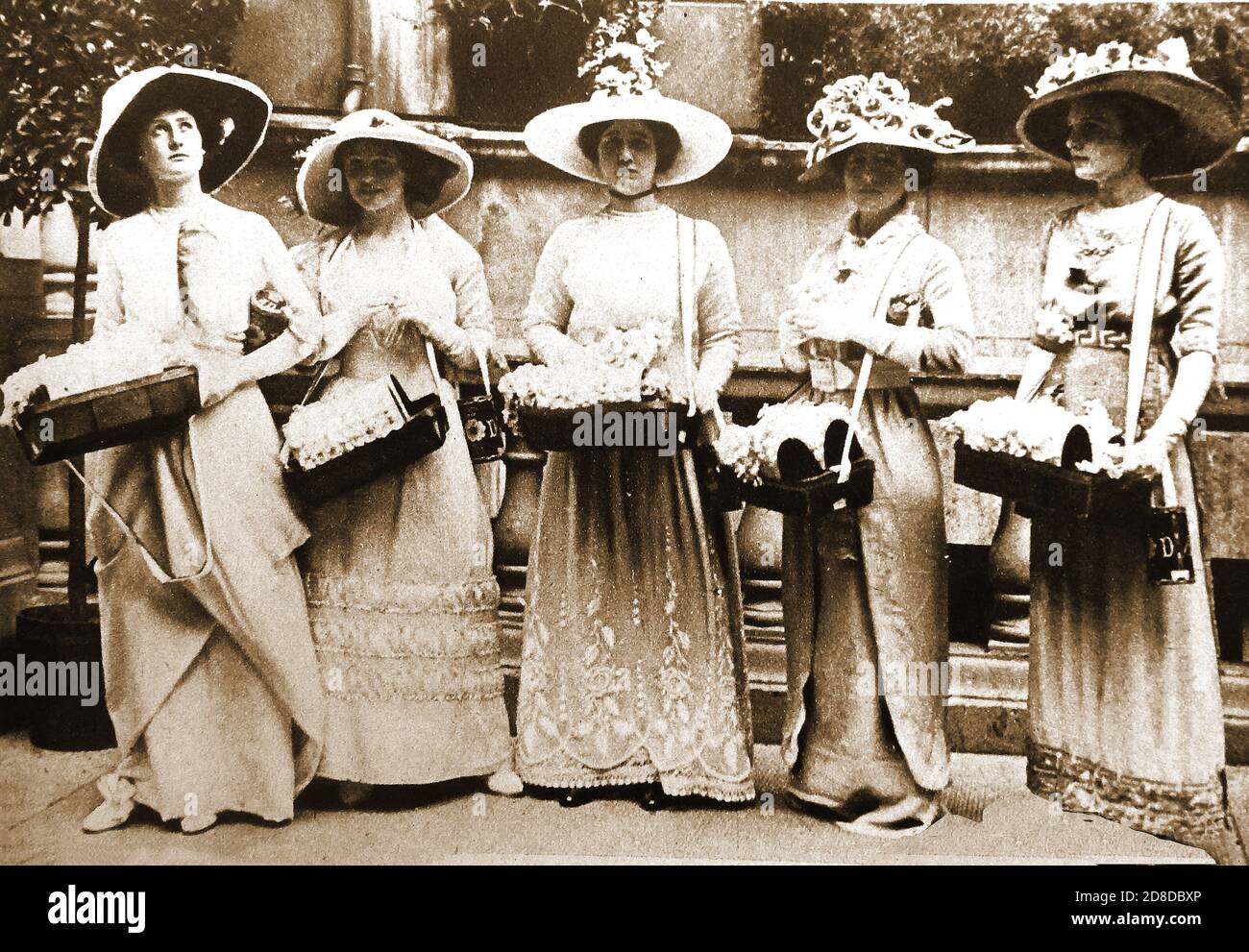 1912. Ein altes Foto von fünf Frauen, die am ersten Alexandra Rose Day Rosen für wohltätige Zwecke verkaufen ----- Der Alexandra Rose Day (im Juni) ist eine karitative Spendenveranstaltung, die seit 1912 von Alexandra Rose Charities in Großbritannien veranstaltet wird. Es wurde zum ersten Mal am 50. Jahrestag der Ankunft von Königin Alexandra aus ihrer Heimat Dänemark in Großbritannien gestartet die Königin bat darum, dass der Jahrestag durch den Verkauf von künstlichen Wildrosen in London von jungen Frauen und Mädchen mit Behinderungen aus dem John Groom markiert werden Industrial Training Home, um Mittel für ihre Lieblings-Wohltätigkeitsorganisationen zu sammeln. Stockfoto