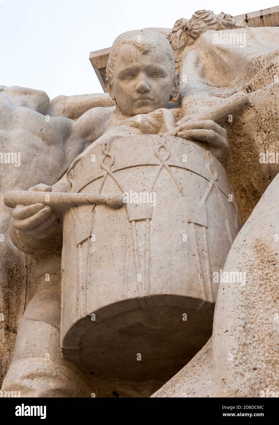 Porträt eines Trommler-Jungen aus Stein, der direkt in die Kamera starrt Stockfoto