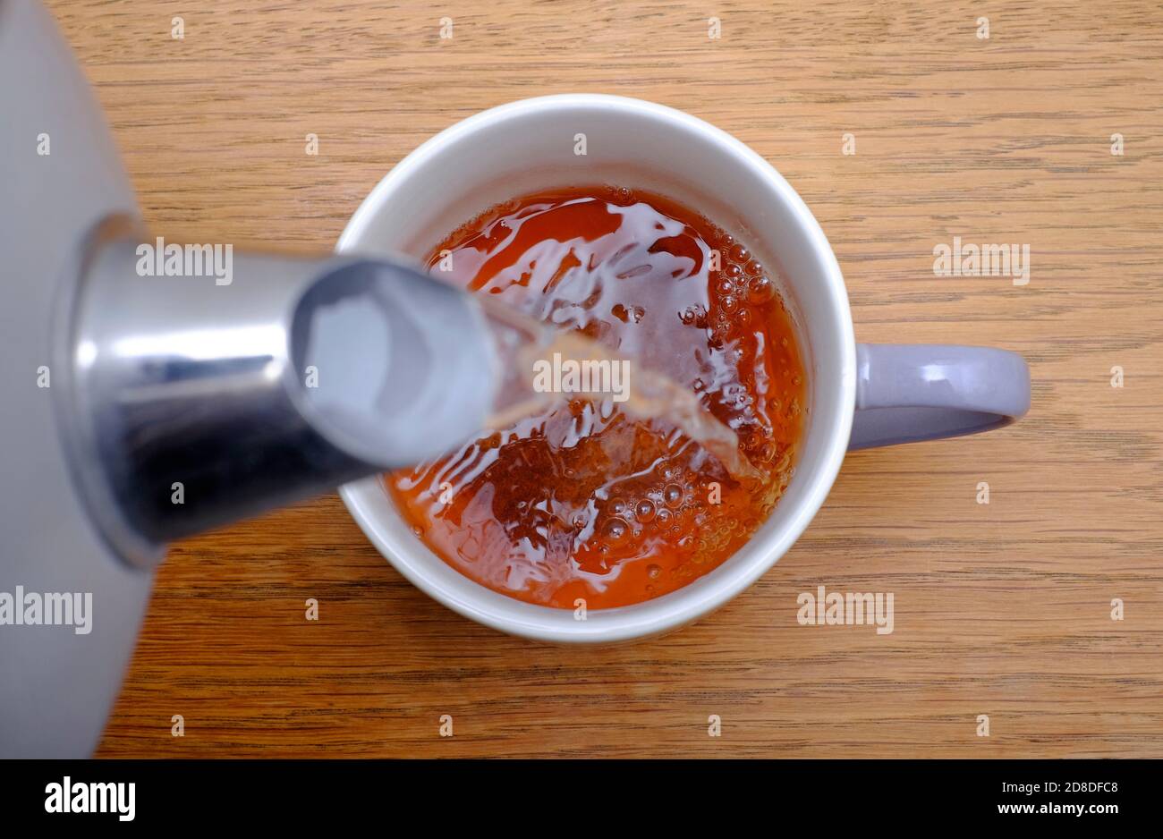 Eine Tasse Tee zubereiten, heißes Wasser über den Teebeutel in der Tasse gießen, norfolk, england Stockfoto