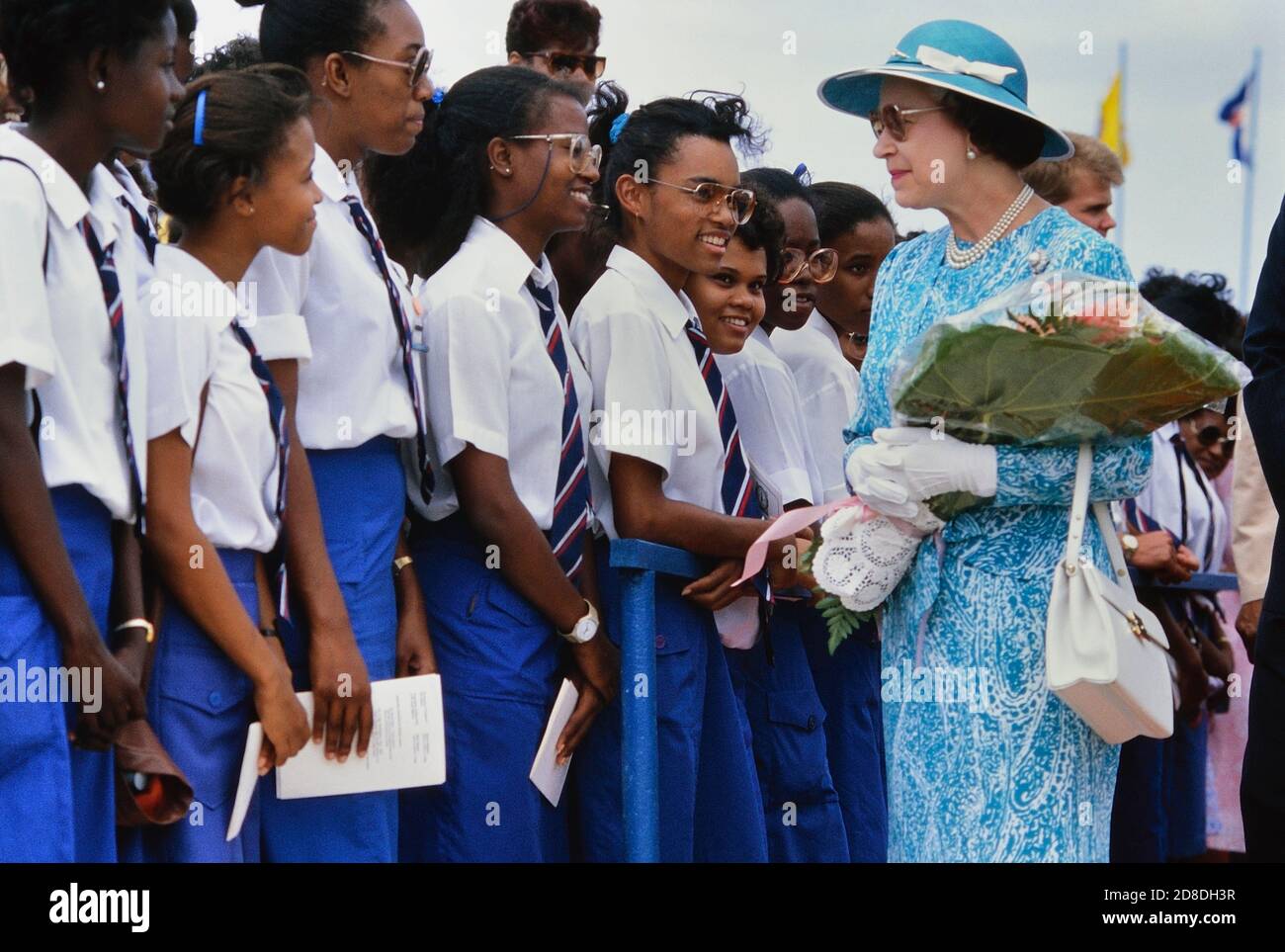 Eine Reihe lokaler Studenten und Schüler grüßen ihre Königliche Hoheit Königin Elisabeth II. Bei ihrem Besuch im Queen's College. Ihre Majestät war bei ihrem letzten Besuch auf der Karibikinsel Barbados. März 1989. Stockfoto