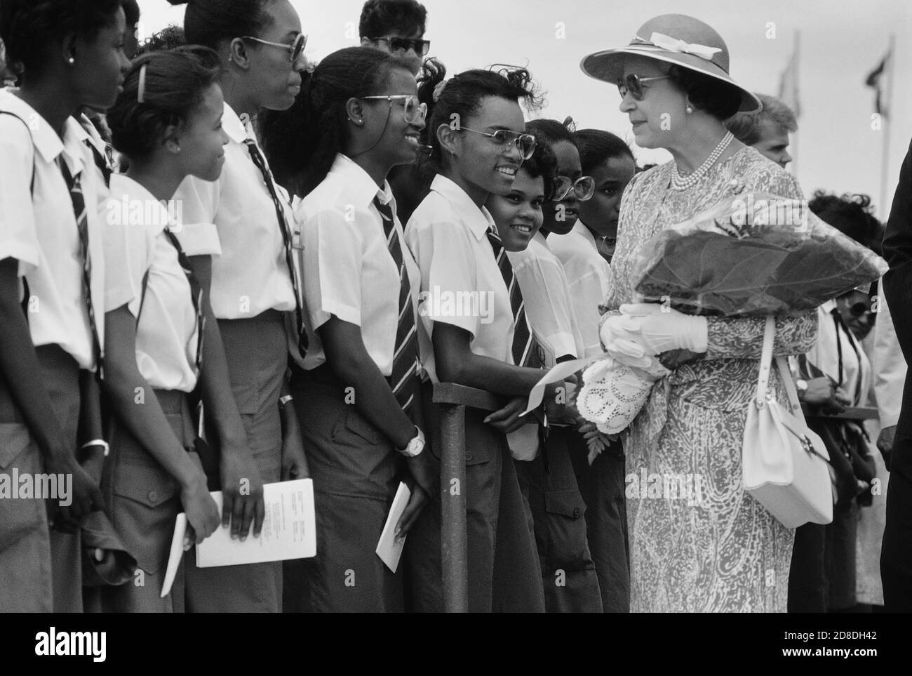 Eine Reihe lokaler Studenten und Schüler grüßen ihre Königliche Hoheit Königin Elisabeth II. Bei ihrem Besuch im Queen's College. Die Königin war bei ihrem letzten Besuch auf der Karibikinsel Barbados. März 1989. Stockfoto