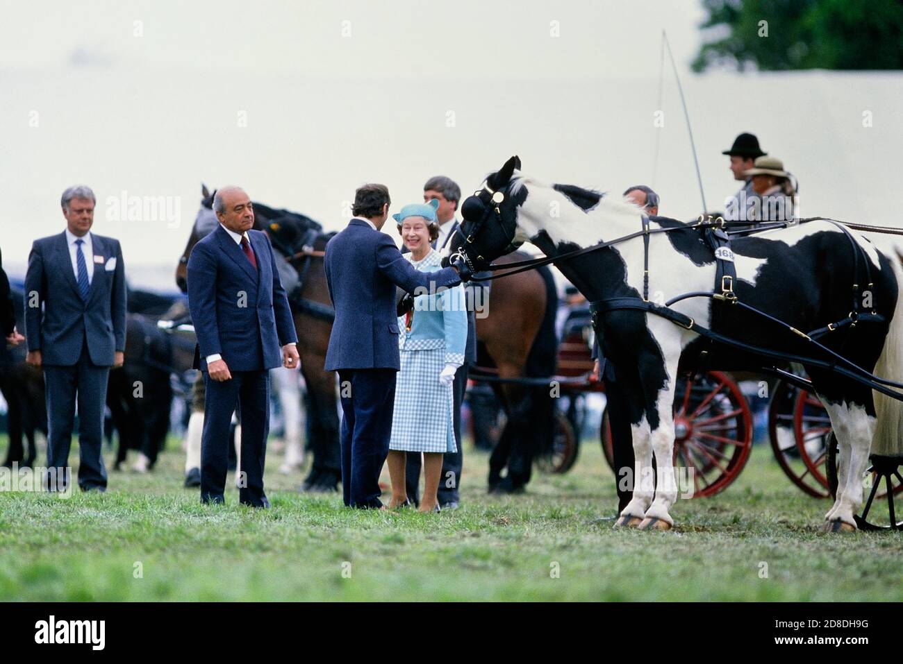 Eine lächelnde Königin Elizabeth II präsentiert Preise auf der Windor Horse Show begleitet von einem der Sponsoren der Show Mohammed Al Fayed vom Harrods Store. Herr Al-Fayed ist der Vater von Dodi Al-Fayed. The Royal Windsor Horse Show, Berkshire, England, Großbritannien. Mai 1989 Stockfoto