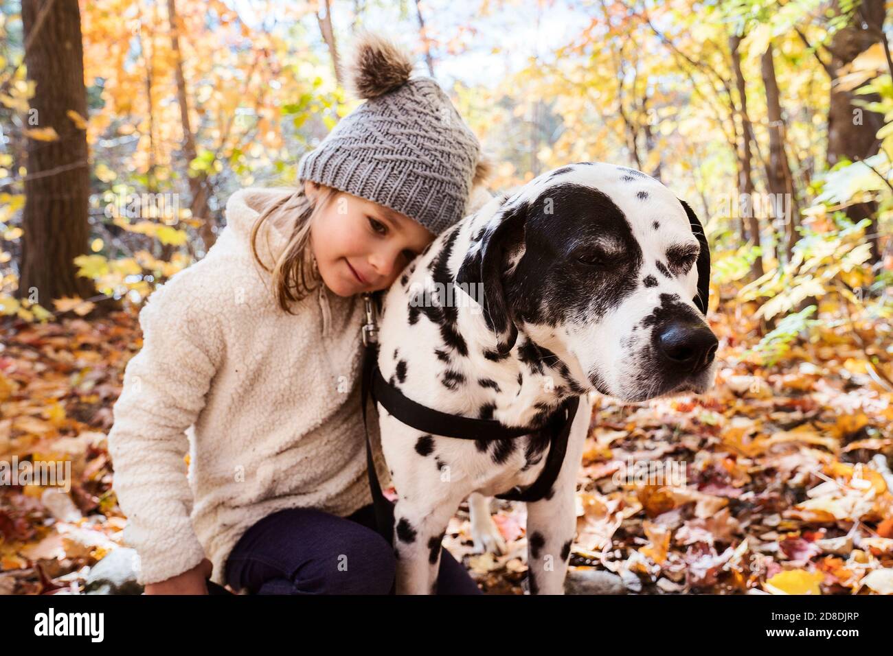 Mädchen mit Dalmatianer Hund in der Herbstsaison Stockfoto