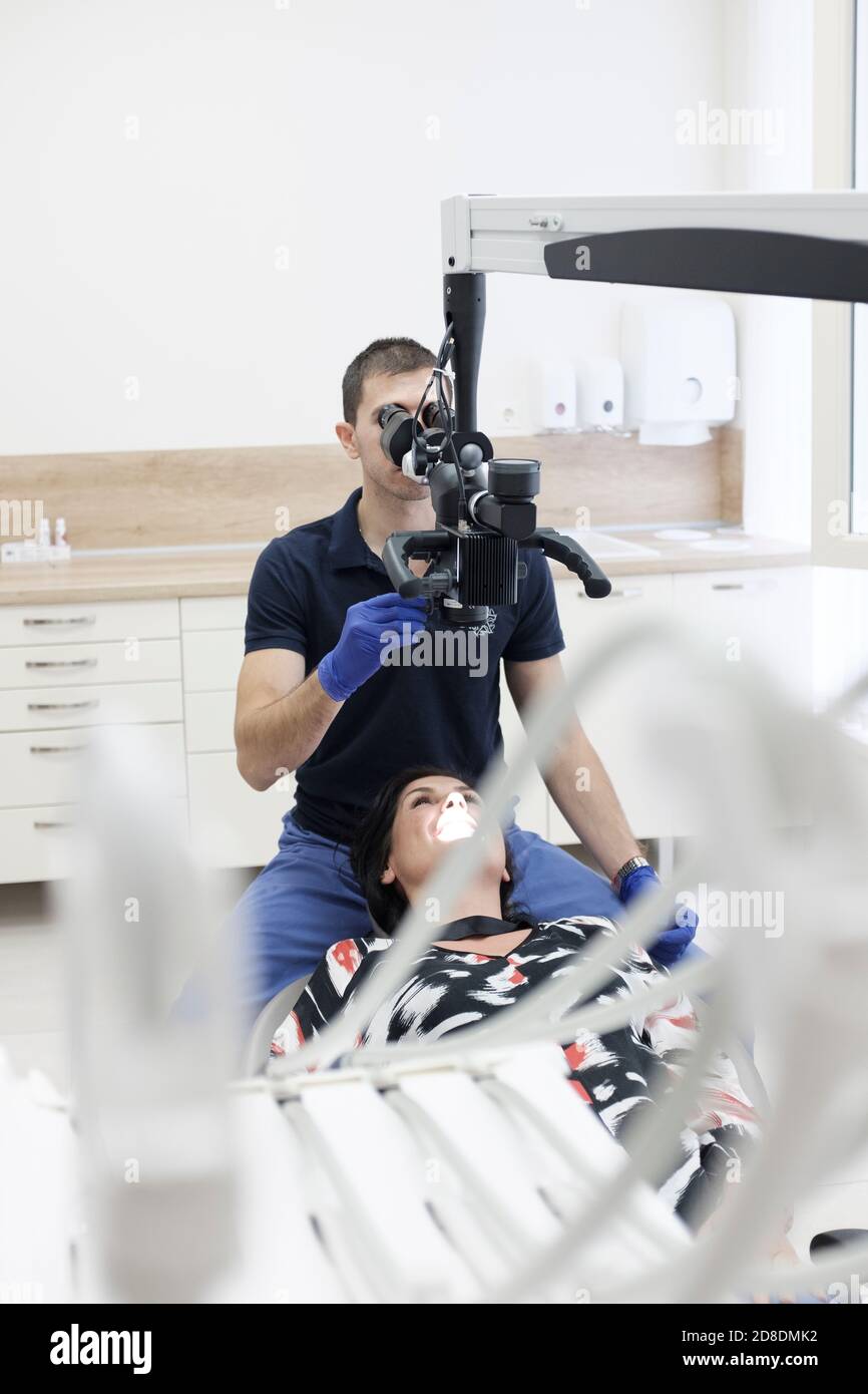 Zahnarzt bei der Arbeit mit Zahnmikroskop Stockfoto