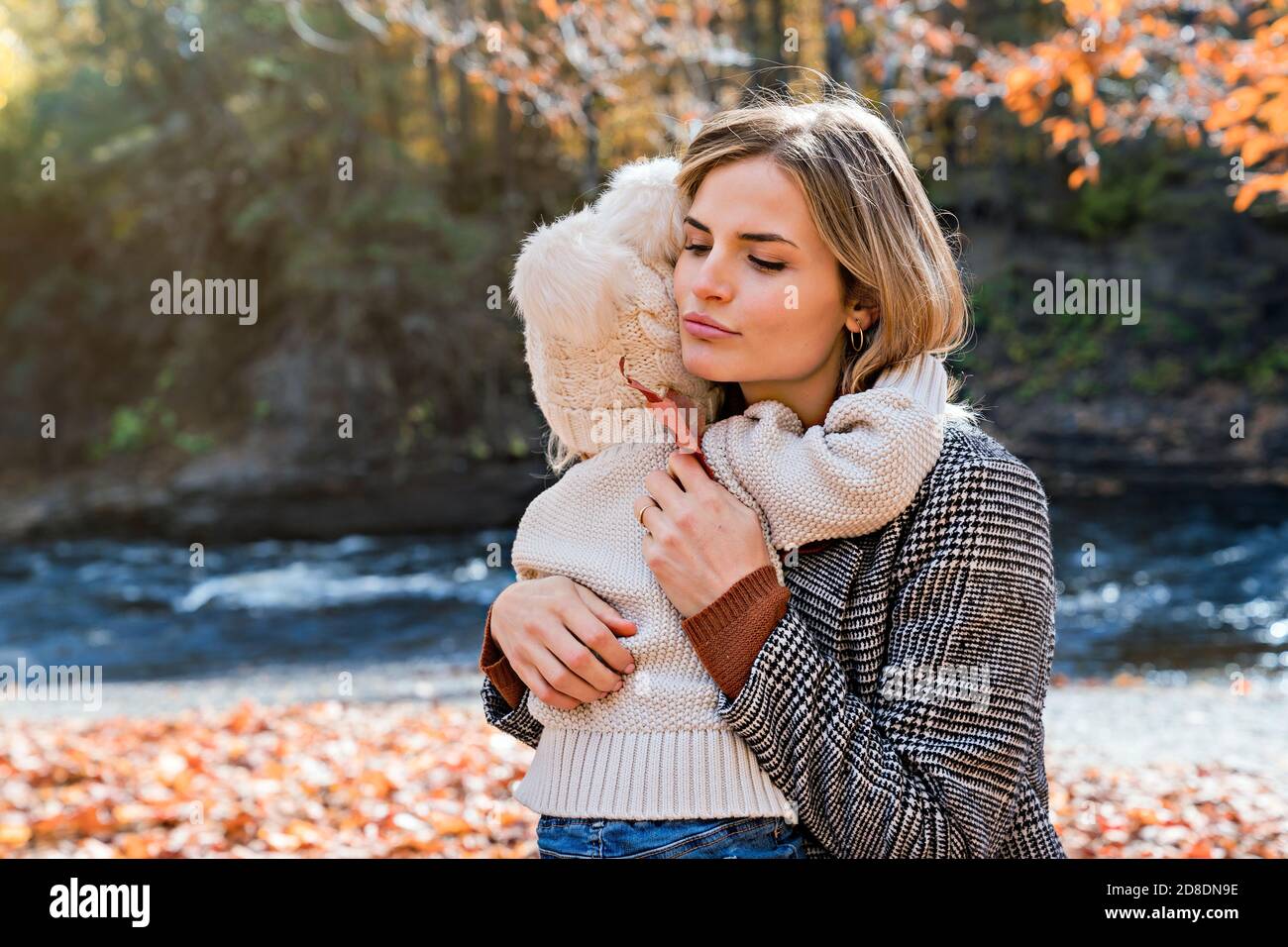 Kleines Mädchen und ihre Mutter umarmen und trösten in der Herbstpark Stockfoto