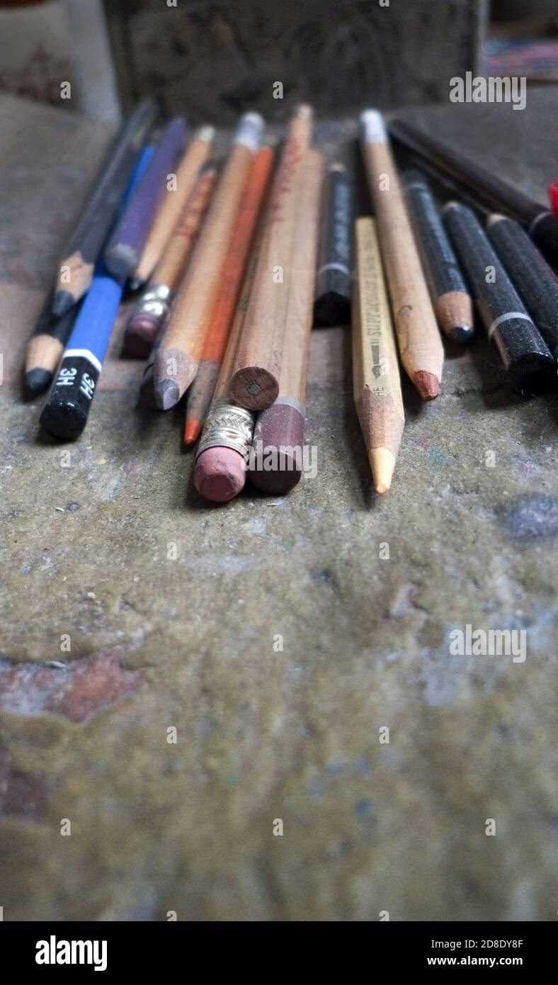 Wählen Sie den Fokus auf eine Vielzahl von Graphit- und Buntstiften Auf einem Holztisch im Atelier eines Künstlers Stockfoto