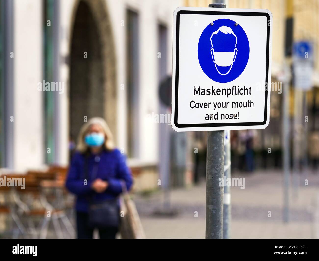 München, 26. Oktober 2020: Ein Schild mit einem Maskenpiktogramm und der Aufschrift "Maskenanforderung" befindet sich auf dem Max-Joseph-Platz in München, Bayern, Deutschland --- München, 26.10.2020: Ein Schild mit Masken-Piktogramm und der Aufschrift "Maskenpflicht" steht am Münchener Max-Joseph-Platz, München, Bayern, Deutschland Stockfoto