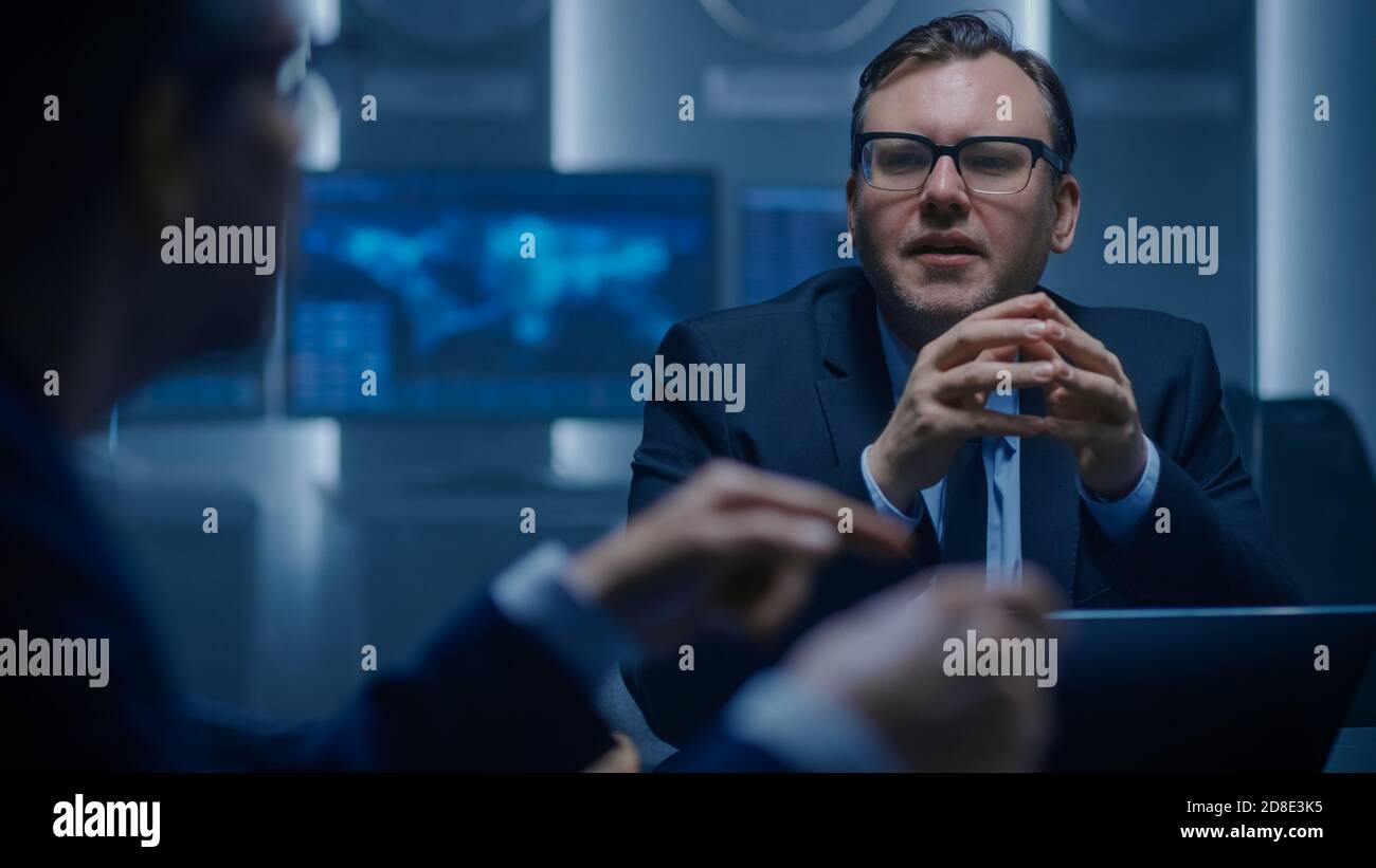 Die Konzernleitung debattiert mit seinem Kollegen aus dem Verwaltungsrat bei einer Sitzung. Seriöse Geschäftsleute: Problemlösung, Verhandlung und Strategieentwicklung Stockfoto