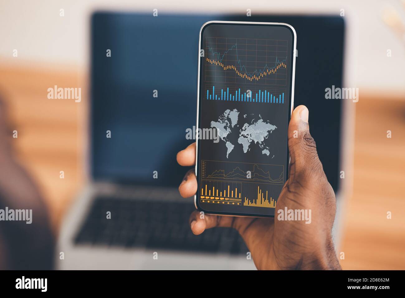 Mobile Trading. Schwarzer Geschäftsmann Holding Smartphone Mit Börsendaten Auf Dem Bildschirm Stockfoto