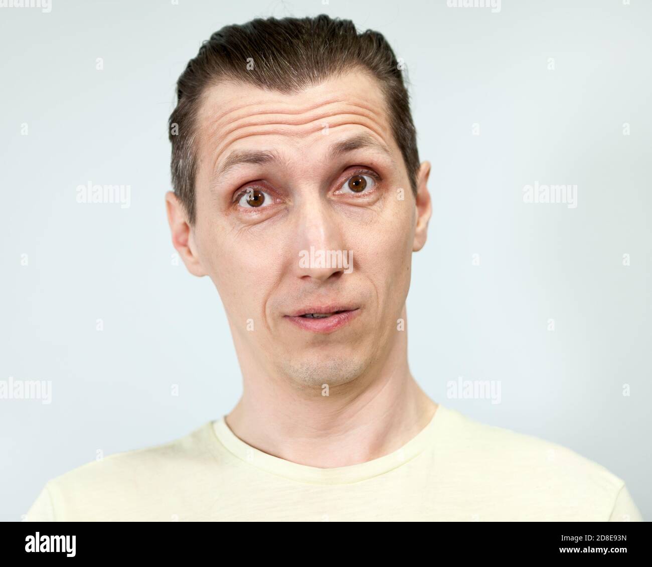 Porträt eines überraschten Mannes, grauer Hintergrund, Emotionen-Serie Stockfoto