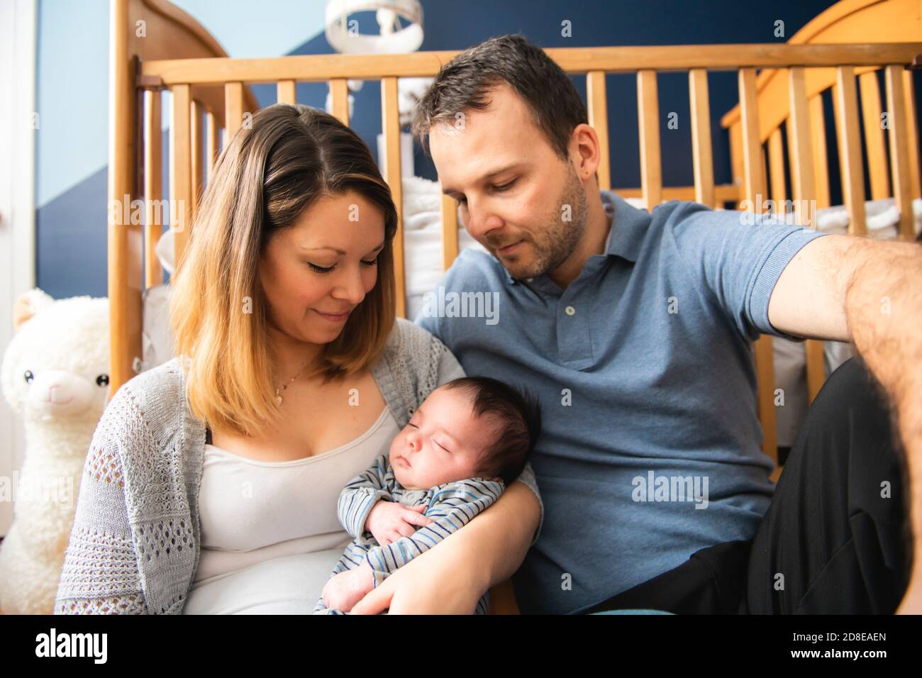 Die Eltern sitzen in der Kinderstube mit Baby-Sohn Stockfoto
