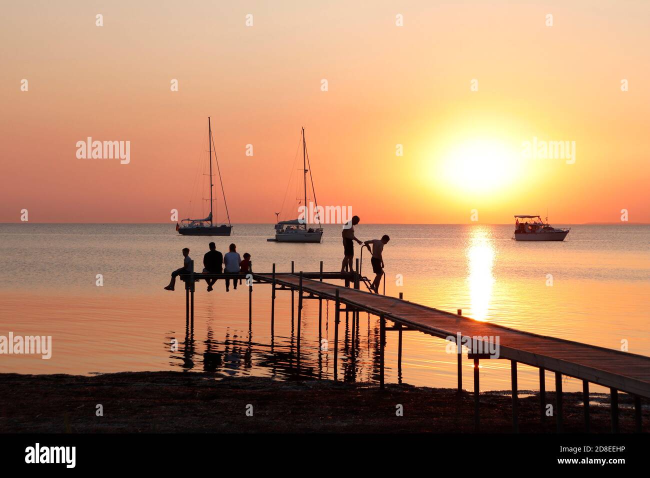 Menschen im Silhouett bei beeindruckendem Sonnenuntergang mit Booten. Gedser Dänemark. Stockfoto