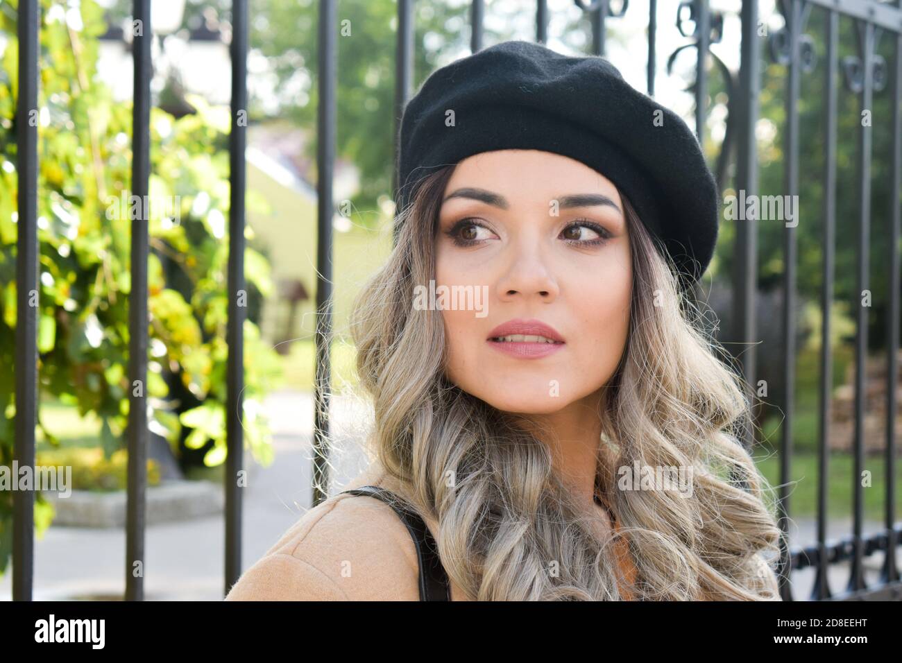 Schöne Frau mit schwarzem Baskenmütze, im Freien Stockfoto