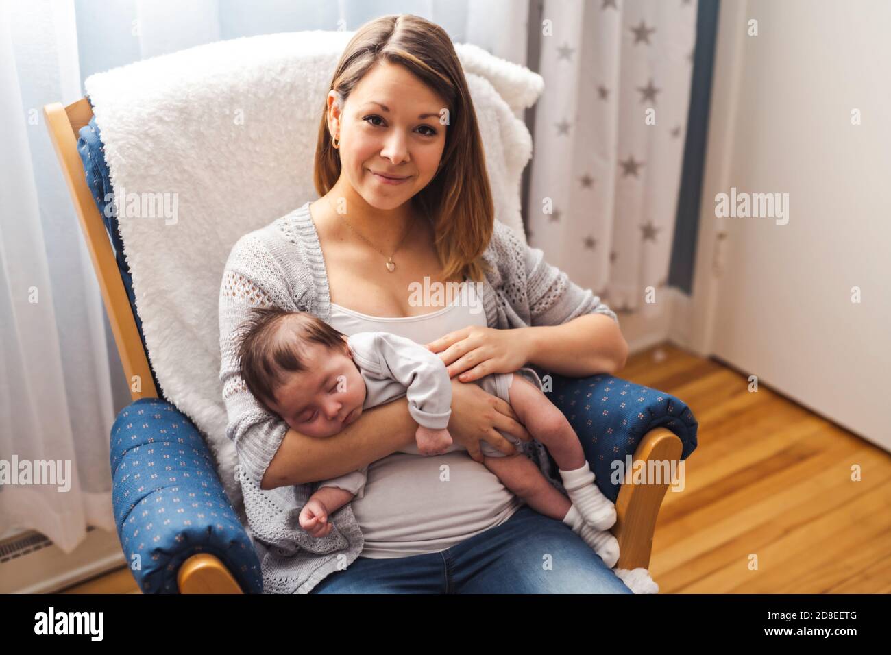 Mama und Baby mit wunderbaren Zeit sitzen auf einem Stuhl Das Schlafzimmer Stockfoto