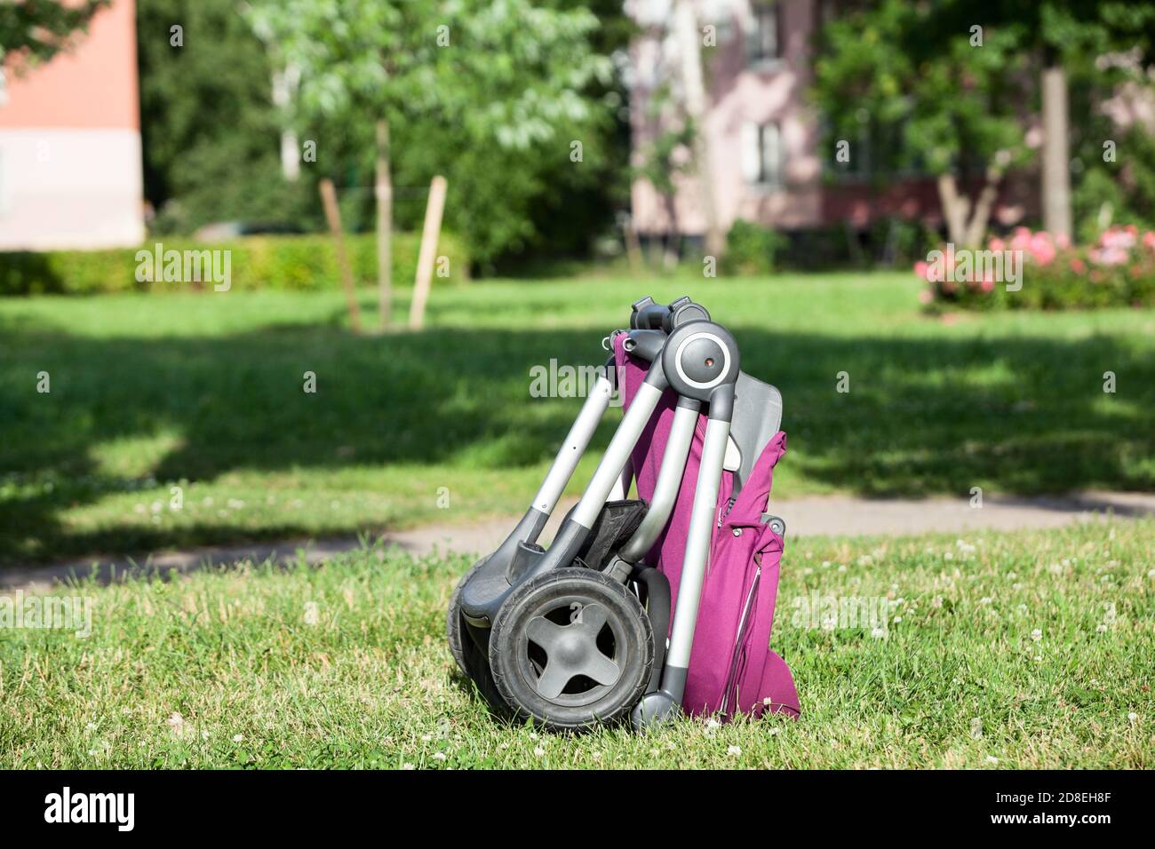 Gefaltete Baby Kinderwagen ist auf grüner Wiese im Sommer sonnigen Park, Säugling perambulator Serie Stockfoto