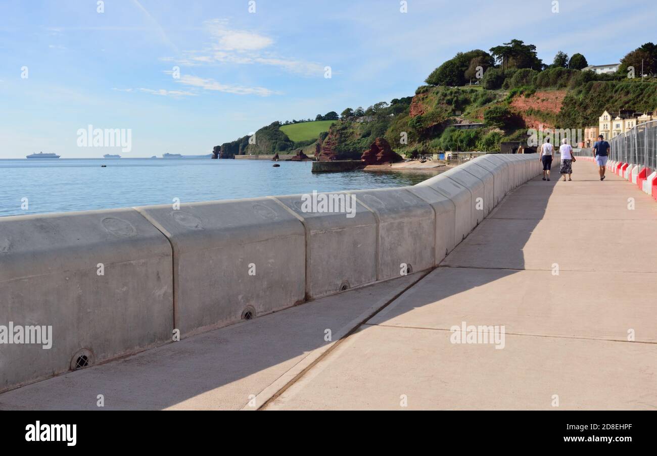 Die neue Ufermauer in Dawlish, kurz vor der Fertigstellung. Beachten Sie die Kreuzfahrtschiffe vor der Küste während der Coronavirus-Pandemie verankert. Stockfoto