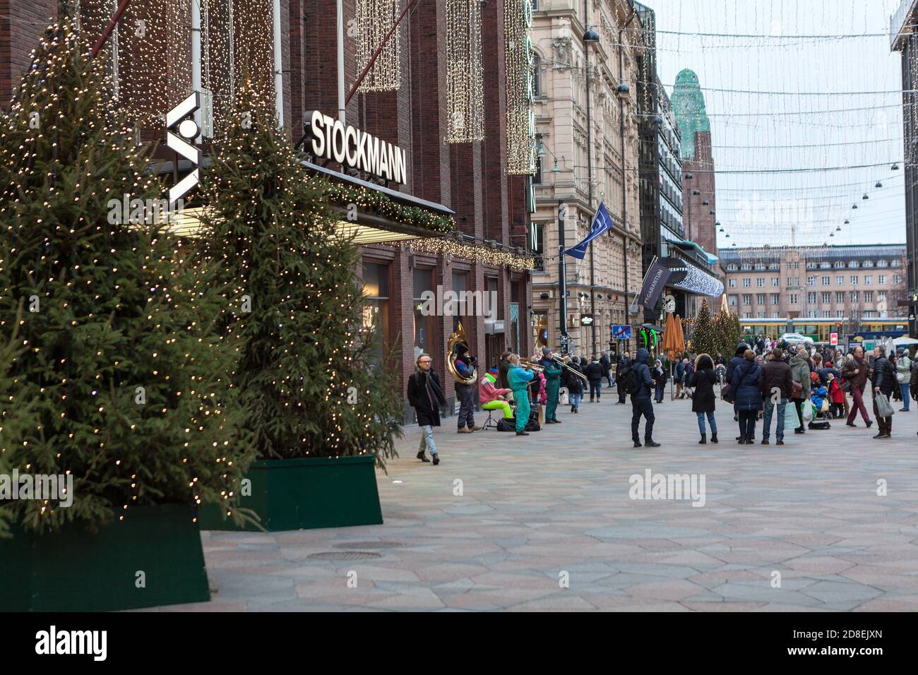 HELSINKI, FINNLAND-CIRCA DEZ, 2018: Straßenmusiker spielen am Weihnachtsabend im Dezember auf dem Platz in der Nähe des Stockmann-Einkaufshauses. Der Stockmann ist Th Stockfoto