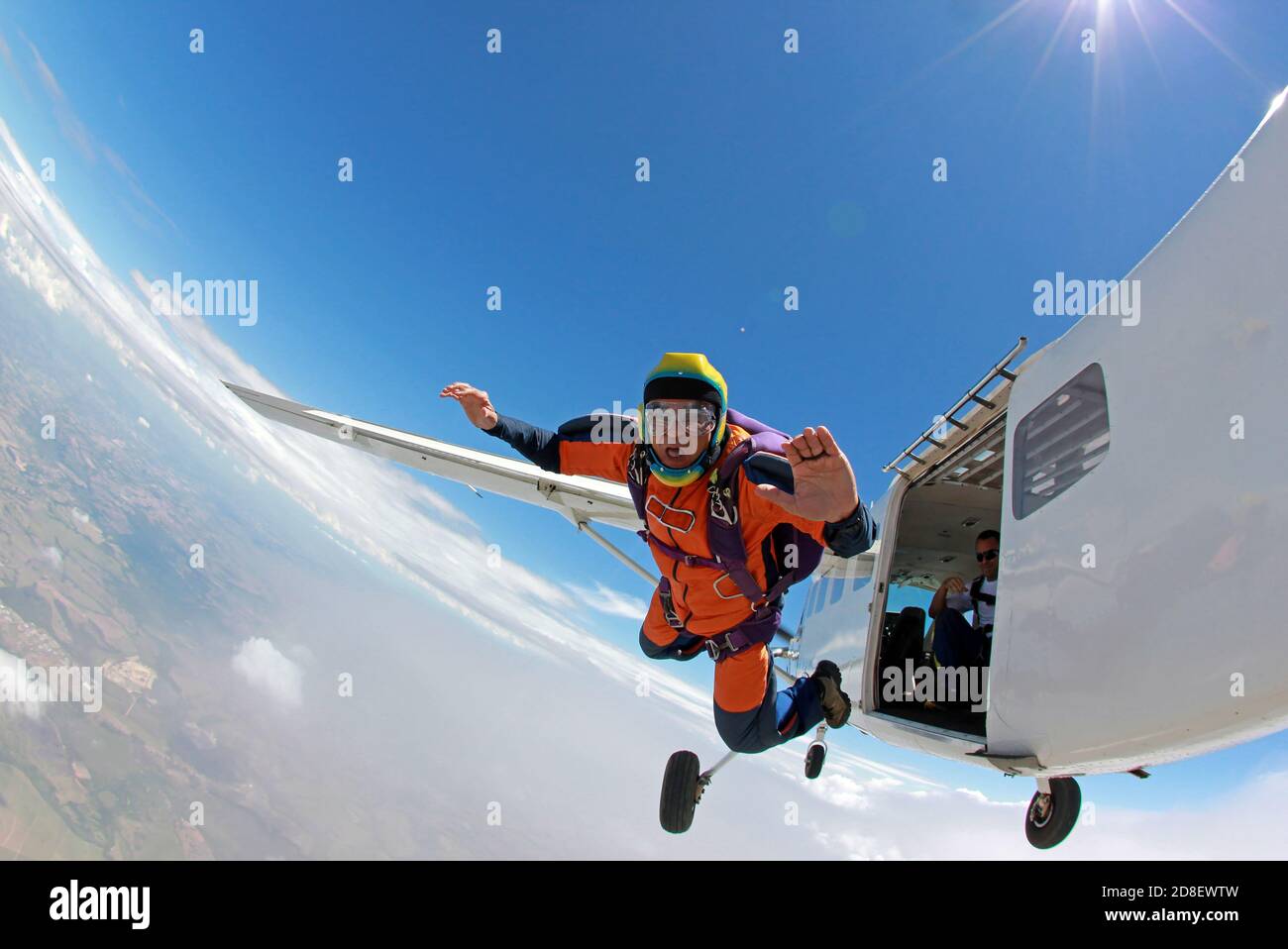 Alter Mann, der einen Traum verwirklicht und aus einem Flugzeug springt Stockfoto