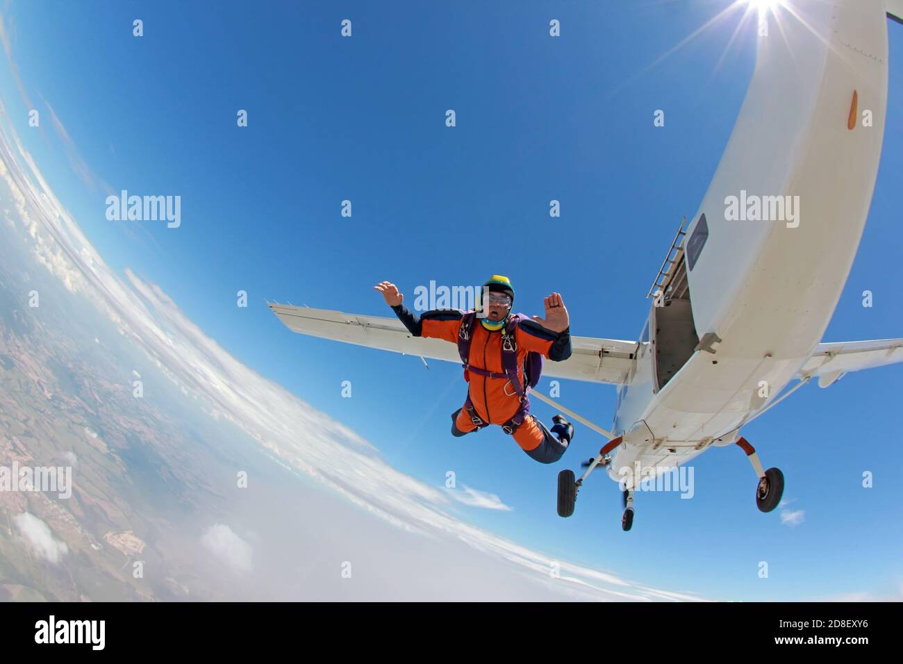 Alter Mann, der einen Traum verwirklicht und aus einem Flugzeug springt Stockfoto
