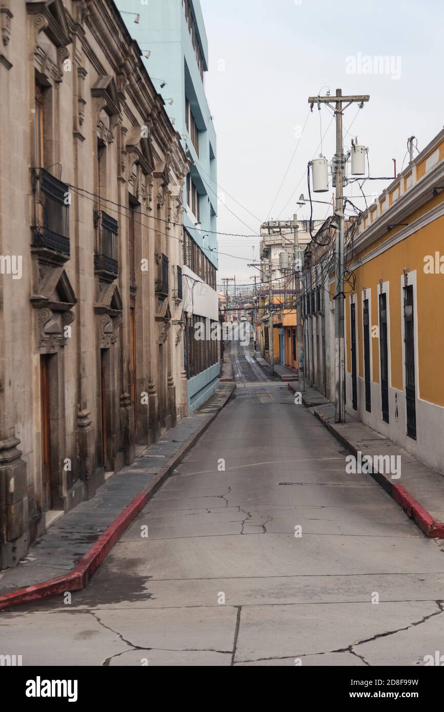 Enge leere Straße der Kolonialstadt am frühen Morgen An einem bewölkten Tag - Straße des historischen Zentrums von Quetzaltenango Guatemala Stockfoto