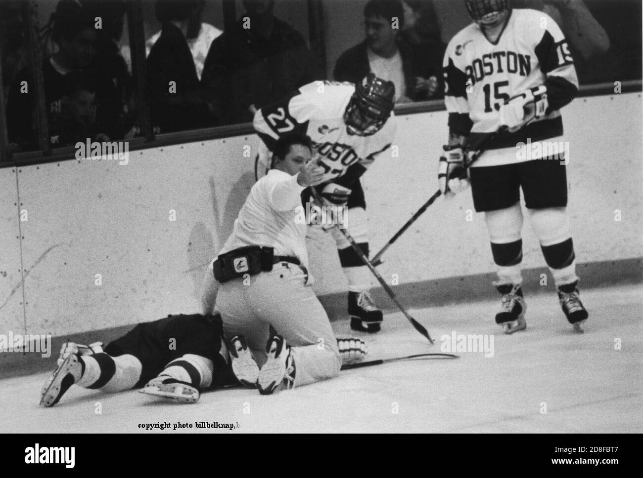 Exklusive Bilder des verletzten Boston University Hockey-Spielers Travis Roy liegt auf dem Eis nach dem Aufschlagen der Boards, Team Trainersignalen für den Teamarzt . Roy wurde in der durch die Verletzung gelähmt. Exklusives Foto von Bill belknap Dez 16,1998 Stockfoto