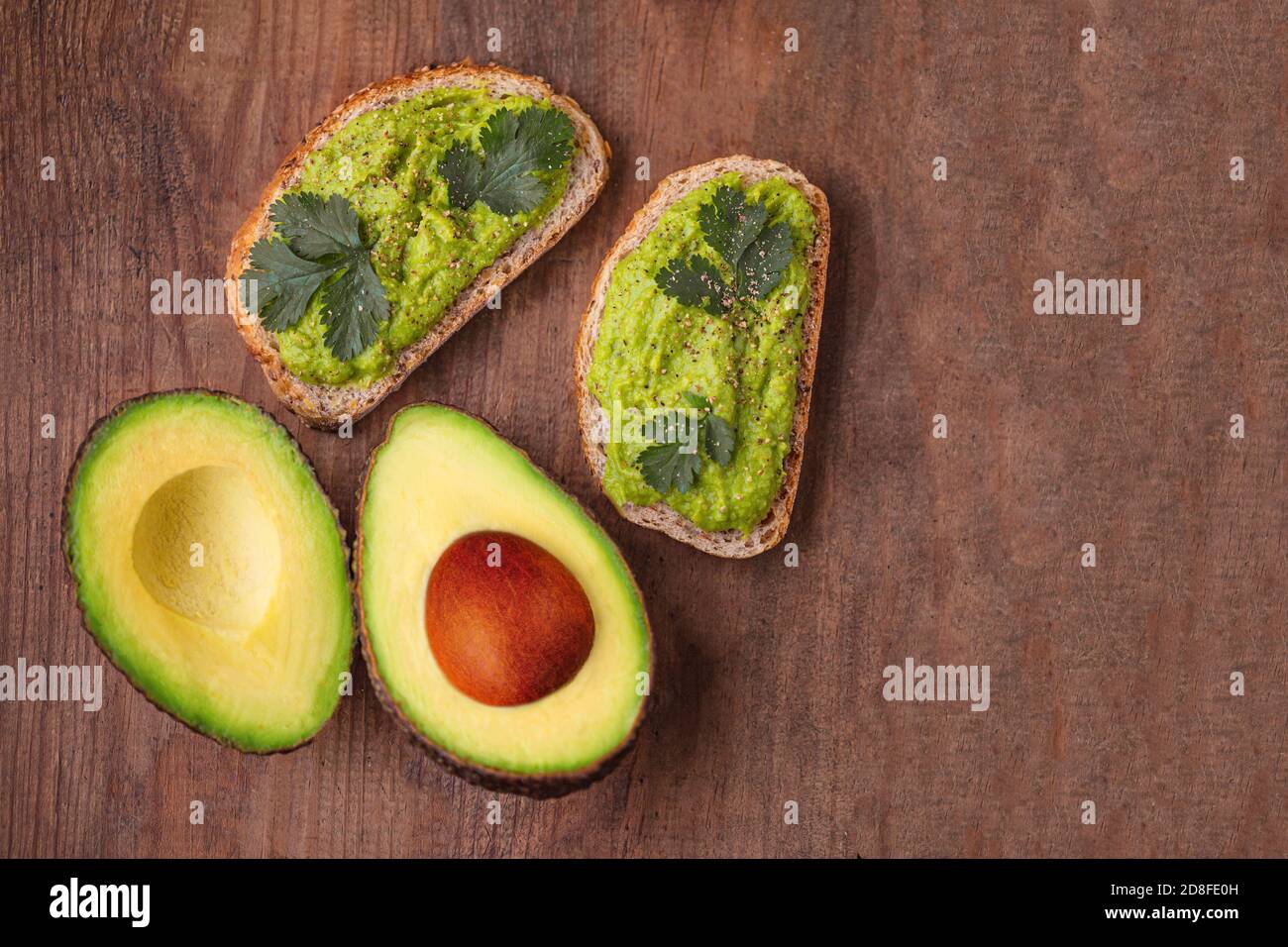Gesunde Ernährung Hintergrund mit frischen Avocado und Guacamole Sauce auf alten Holztisch, Draufsicht, Kopierraum Stockfoto