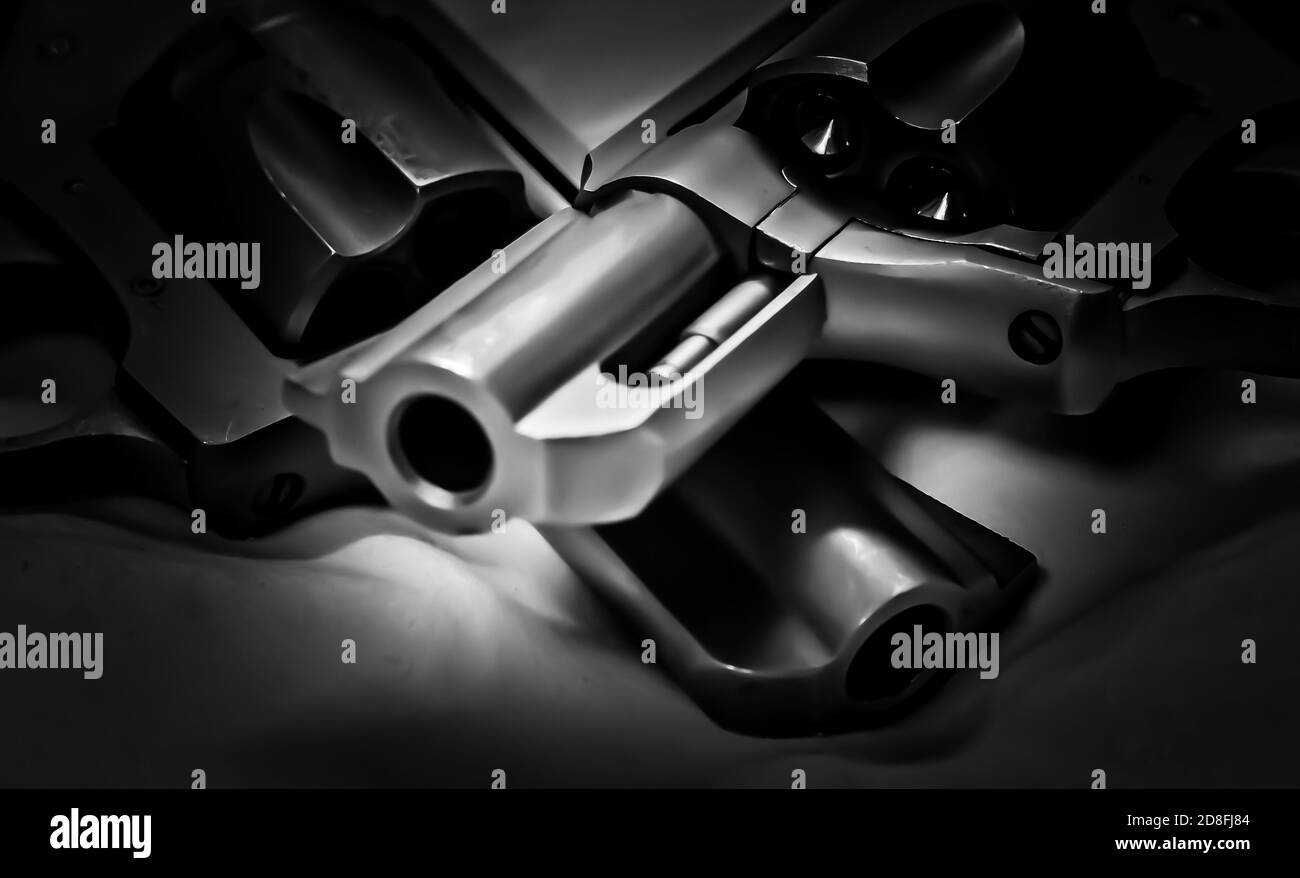 Zwei Pistolen, ein Edelstahl 357 und ein schwarzer 38 Spezialrevolver auf schwarzem Hintergrund Stockfoto
