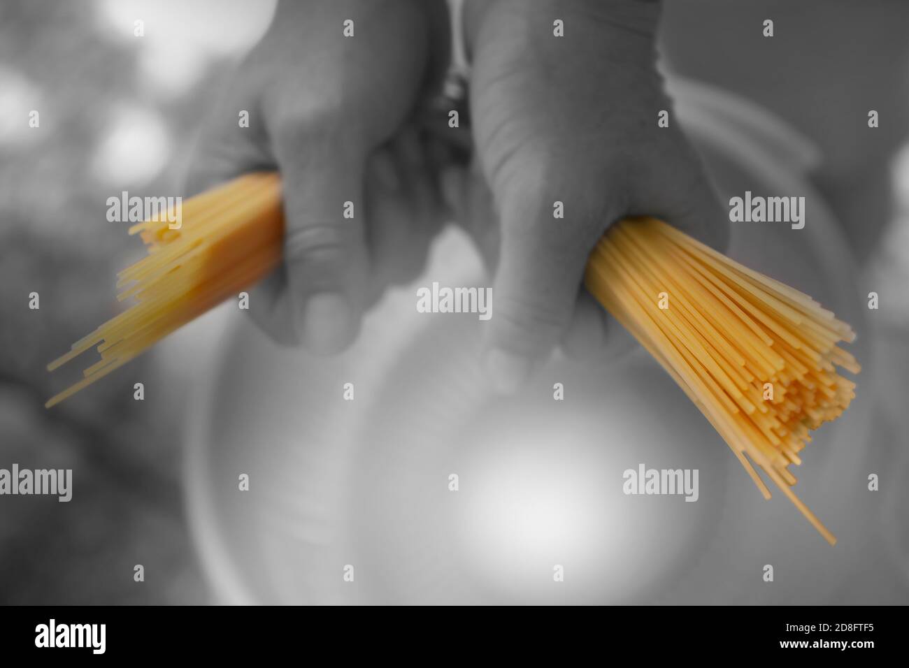 Old Fashioned Schwarz und Weiß kombiniert Foto von verschwommenen Händen Zerbrechen Pasta über einen Topf zu kochen Stockfoto
