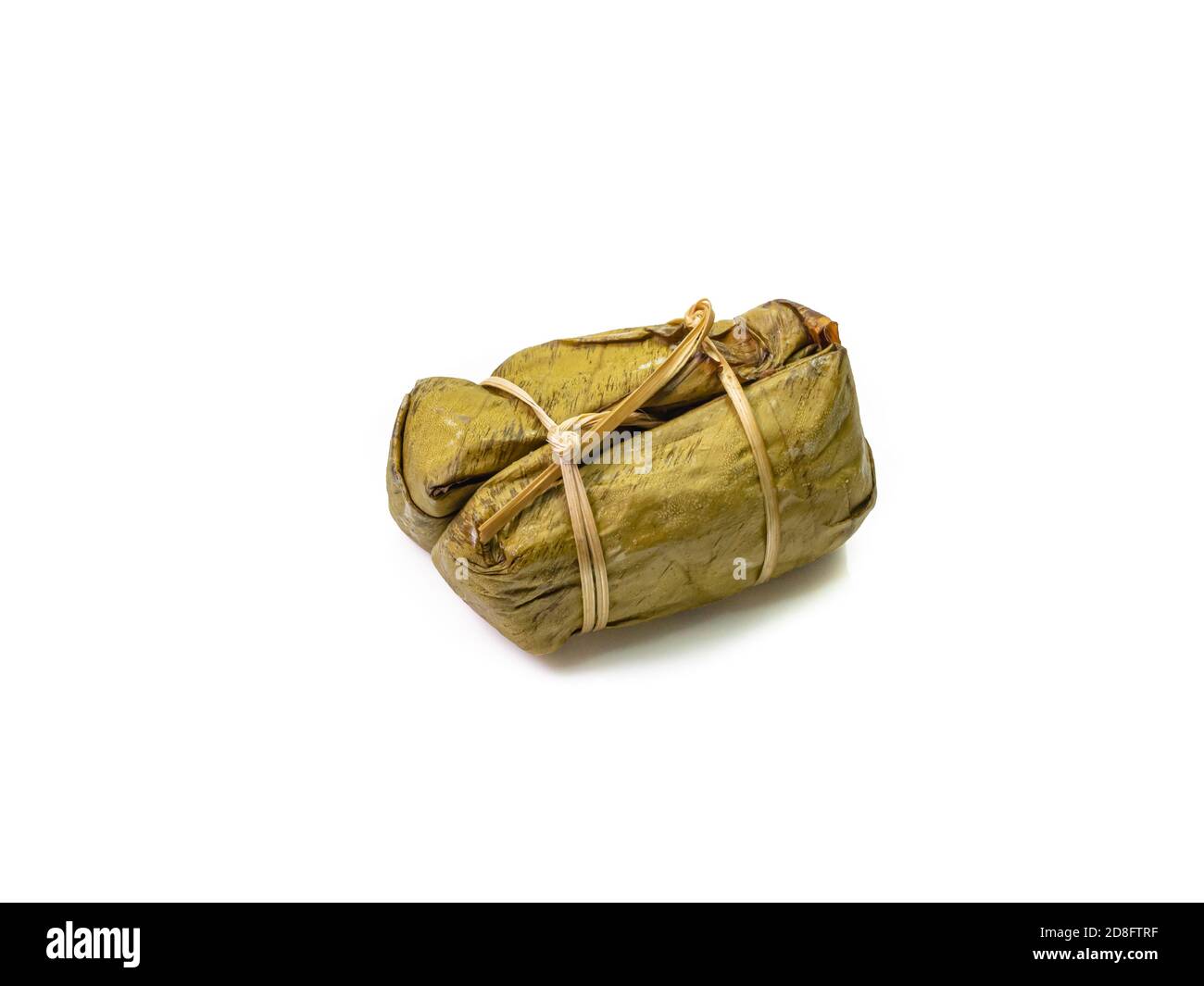 Die Nahaufnahme von Thai gedämpftem klebrigem Reis mit Kokosmilch und Banane (Khao Tom Mud) umhüllt von Bananenblatt auf weißem Hintergrund. Stockfoto