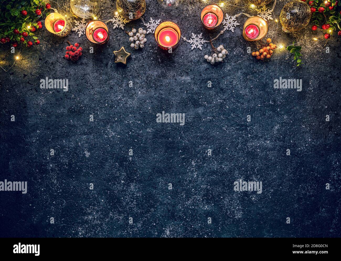 Weihnachtshintergrund mit festlicher Dekoration, Beeren und Kerzen Stockfoto