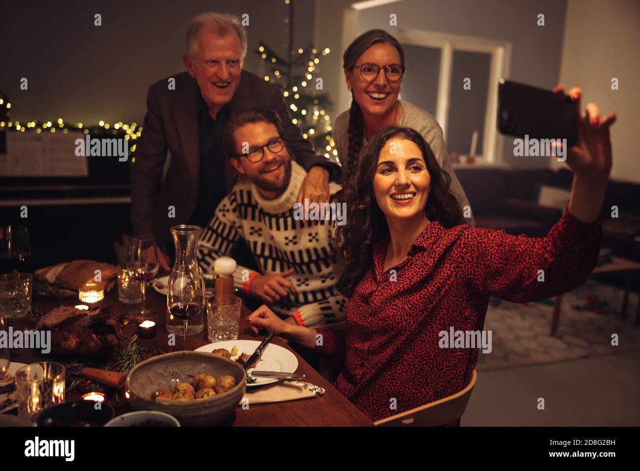 Frau, die am heiligabend Selfie mit der Familie gemacht hat. Europäische Familie nimmt Selfie während Weihnachtsessen.; Stockfoto