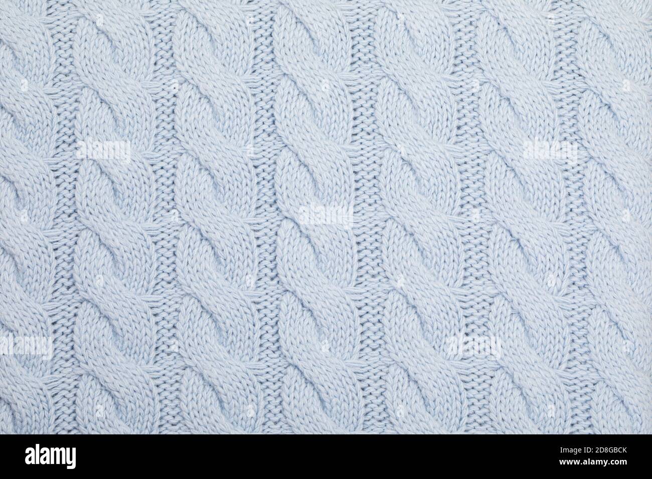 Echt blaue Strickware mit strukturiertem Kabelmuster im Hintergrund Stockfoto