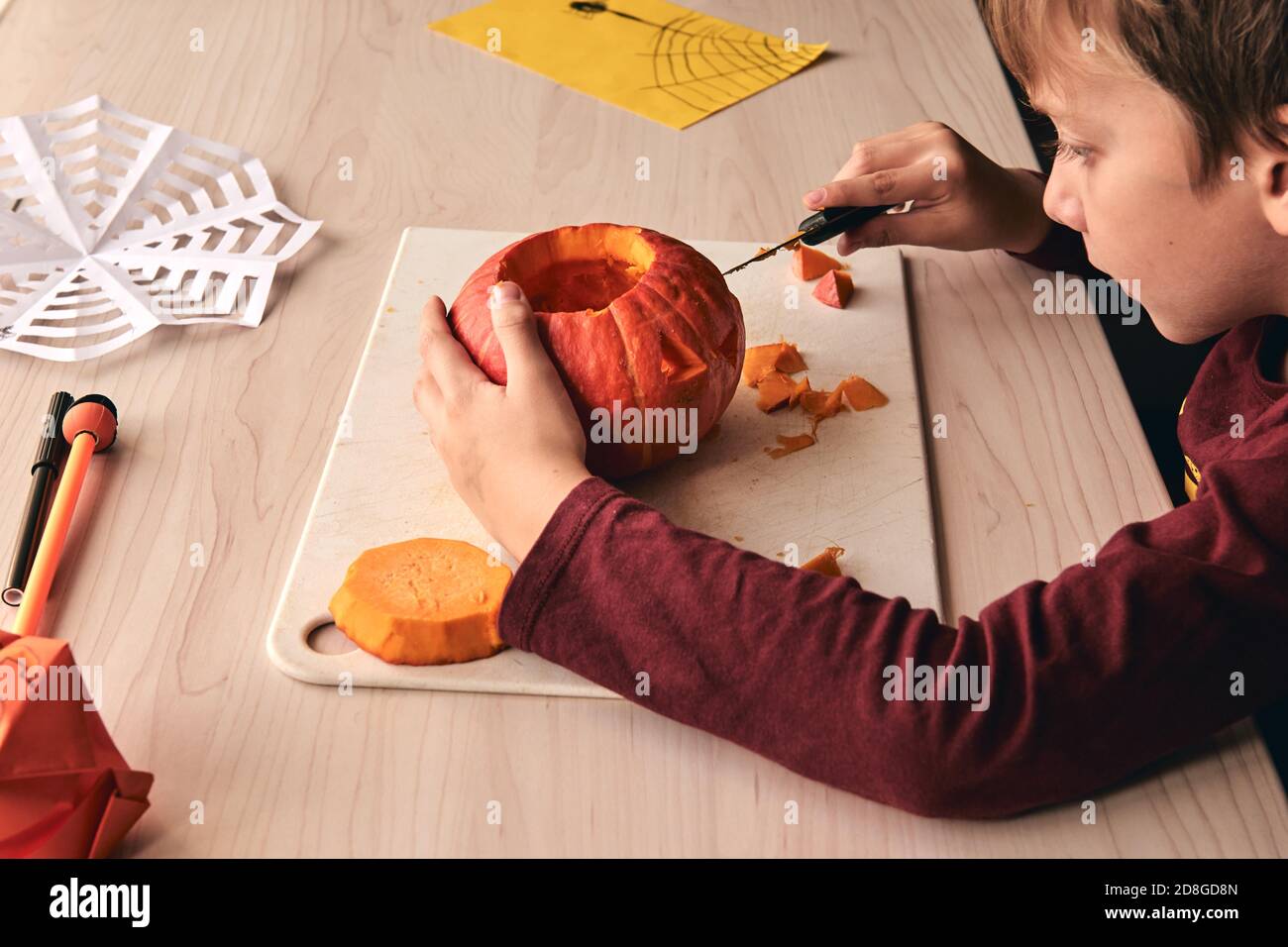 Halloween, Dekoration und Urlaub Ideen- Nahaufnahme des Kindes mit Messer Schnitzerei Kürbis oder Jack-o-Laterne. 6 Jahre junge hat Heimfamilie Spaß Aktivität. Mama Stockfoto