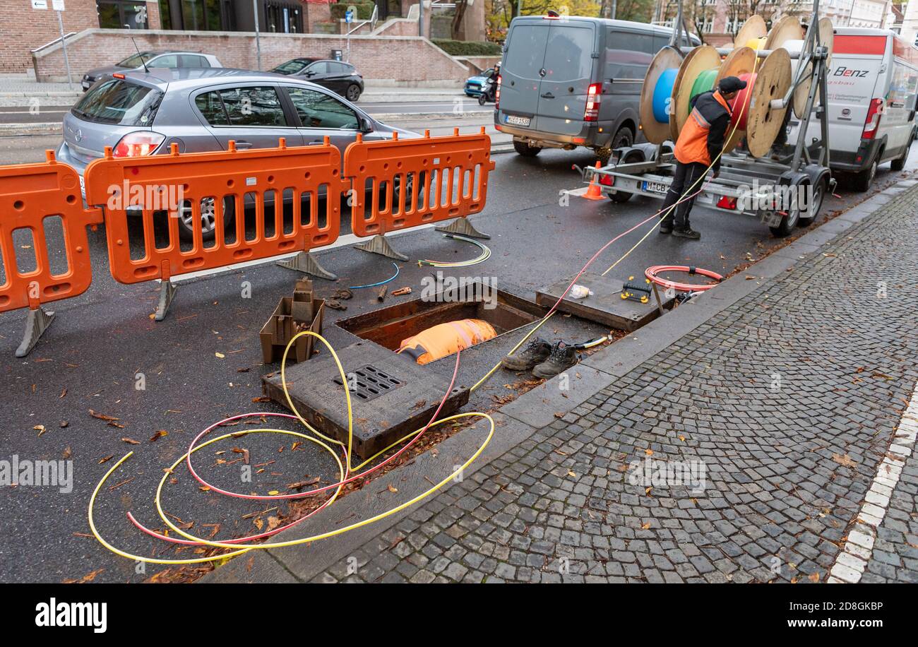 München, Deutschland. Oktober 2020. Arbeiter legen farbige Leerrohre für Glasfaserkabel unter einer Straße ab. Kredit: Peter Kneffel/dpa/Alamy Live Nachrichten Stockfoto