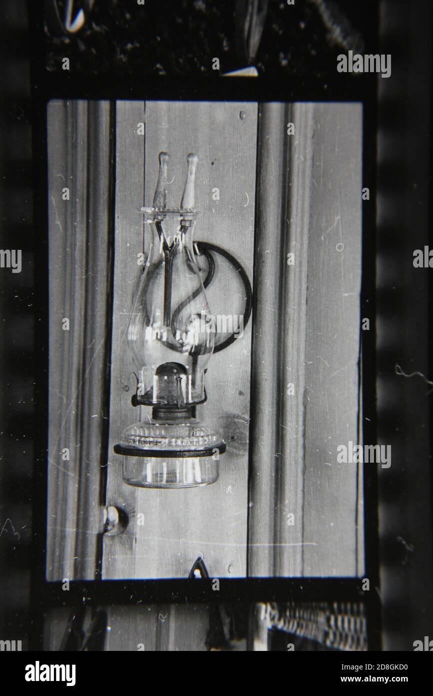 Feine 70er Jahre Vintage schwarz-weiß Fotografie Stillleben einer Öllampe im Fenster eines Landhauses stehen. Stockfoto