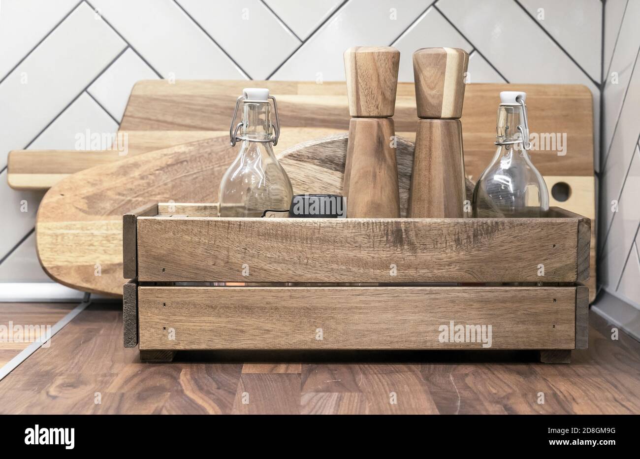 Küchenbox aus Holz mit Gewürzbehältern und Glasflaschen für verschiedene Flüssigkeiten. Stockfoto