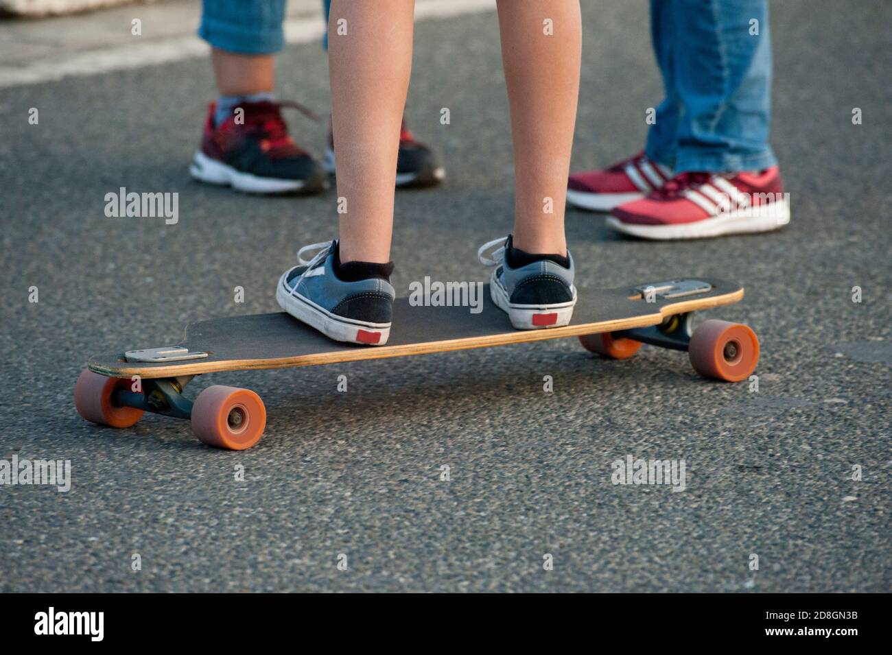 Boy Reiten ein Skateboard, auf der Straße glatten Boden, Beine mit  Sportschuhen Stockfotografie - Alamy