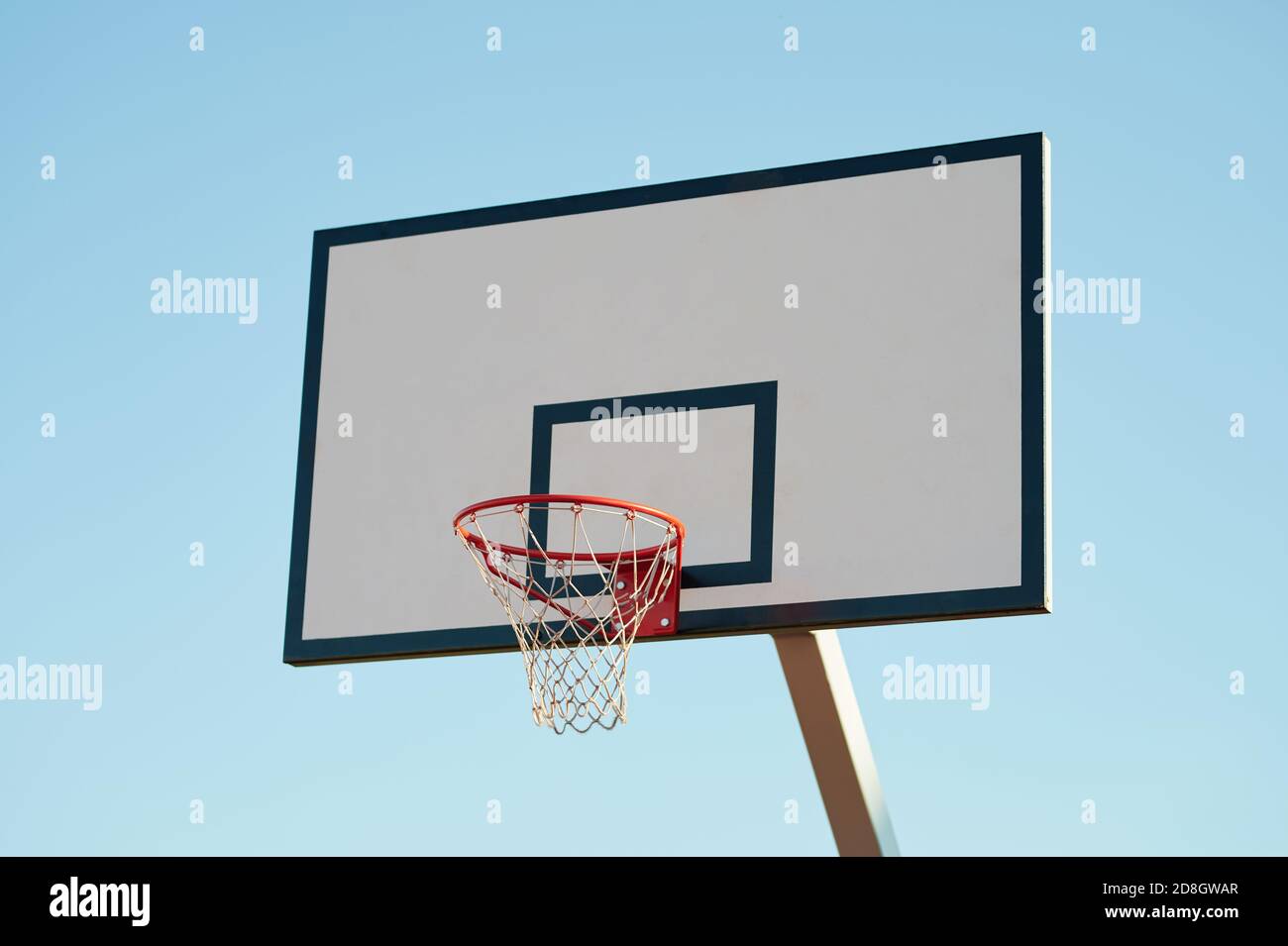 Neues Basketballbrett mit Korb auf blauem Himmel Hintergrund Stockfoto