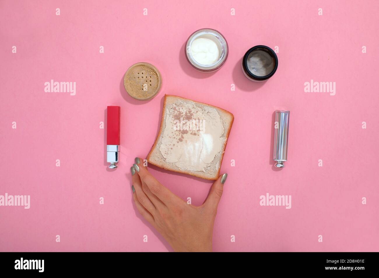 Crop Frau mit Make-up-Produkte auf rosa Tisch Stockfoto