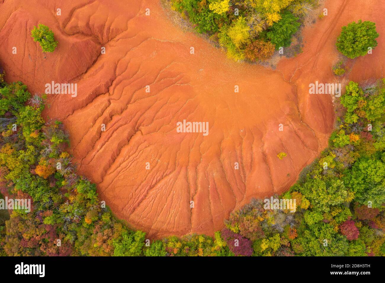 Gant, Ungarn - Luftaufnahme der verlassenen Bauxitmine, Bauxitformation. Rote und orangefarbene Oberfläche, Bauxit-Textur. Warme Herbstfarben. Stockfoto