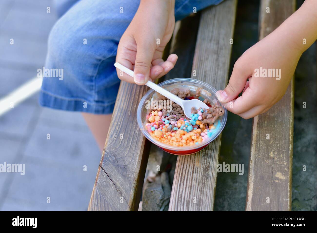 Kinder Hände mit einem Löffel, zum Essen Mini kleine bunte Eiskugeln von  Obst und Schokolade Eis Stockfotografie - Alamy