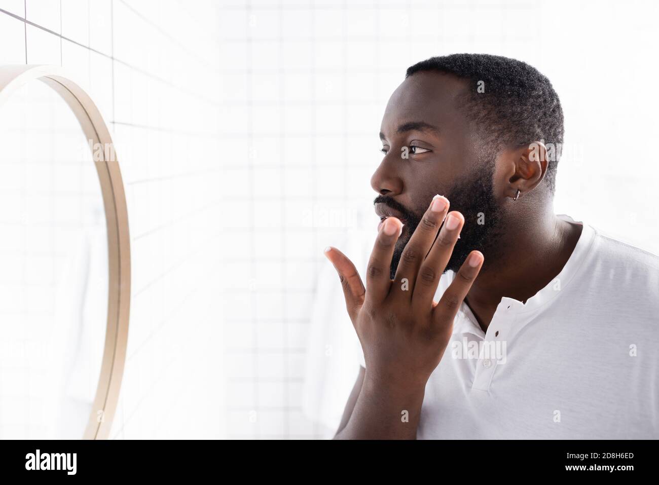 afro-amerikanischer Mann Anwendung Heilung zur Stärkung Bartwachstum Stockfoto
