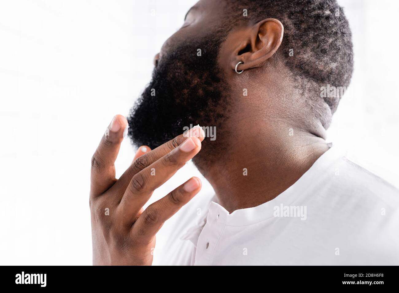 afro-amerikanischer Mann Anwendung Heilung zur Stärkung Bartwachstum Stockfoto