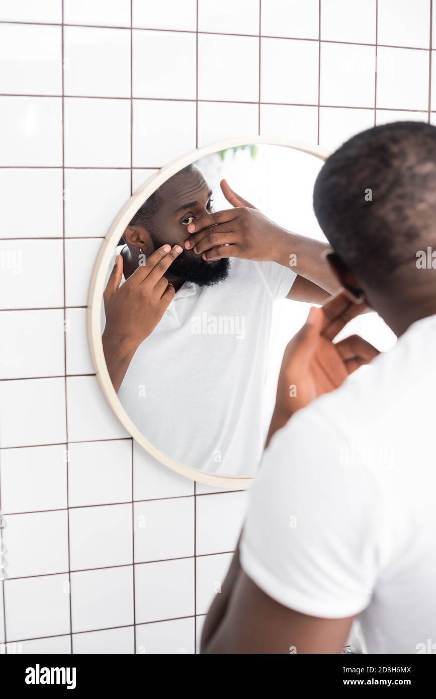 afro-amerikanischer Mann versucht Squeeze Pickel Stockfoto