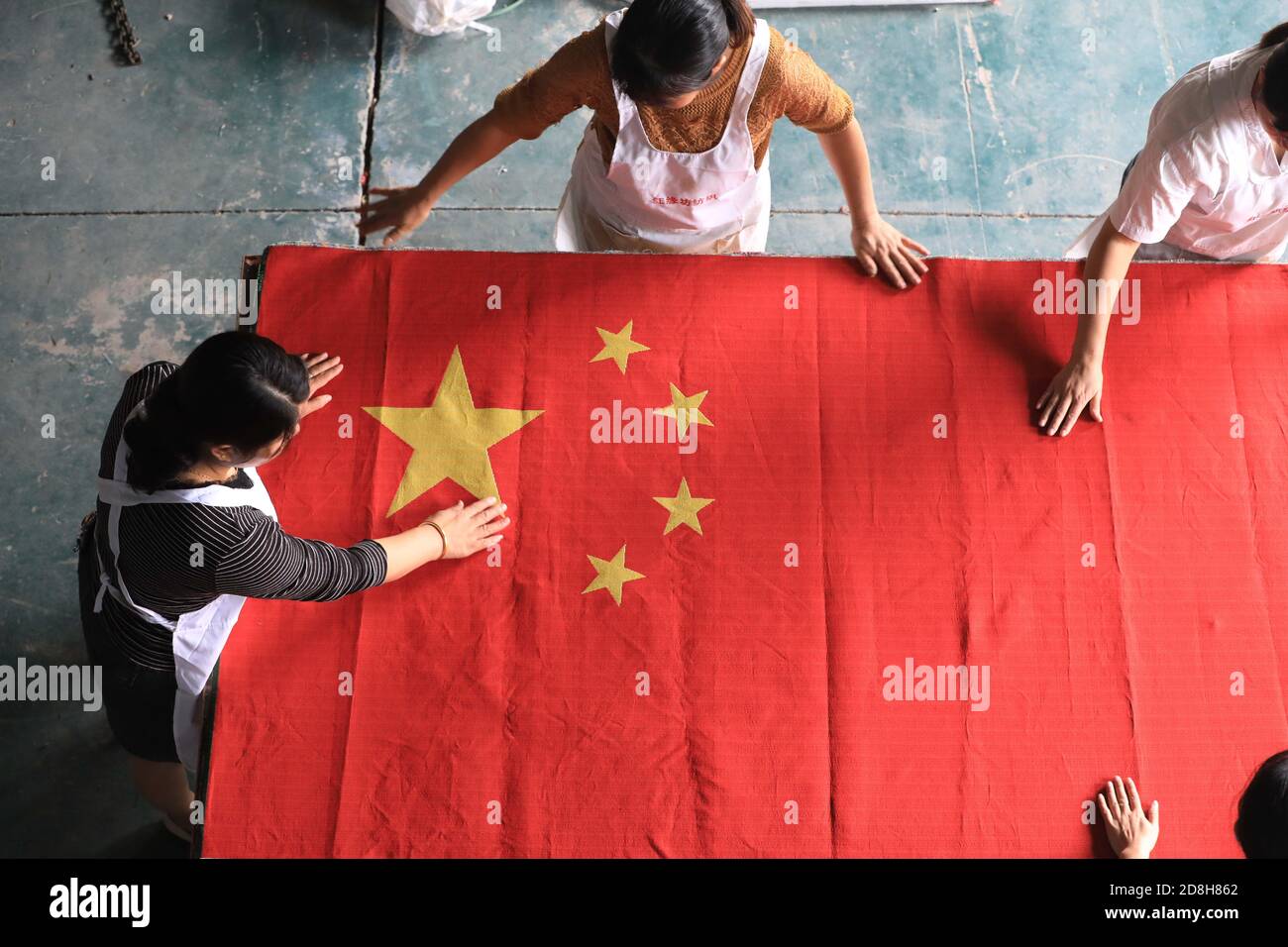 Mitarbeiter der Textilfirma Hongyuanfang organisieren in der Werkstatt in Tianmushan, Bezirk Lin'an, Stadt Hangzhou, Ost-Chi, eine gewebt Nationalflagge Stockfoto