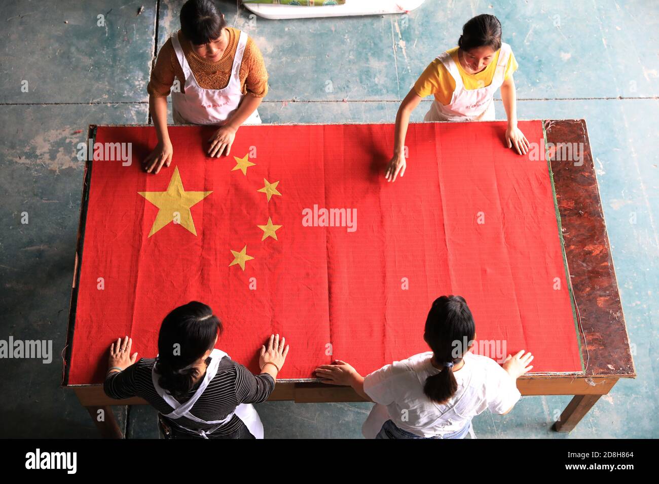 Mitarbeiter der Textilfirma Hongyuanfang organisieren in der Werkstatt in Tianmushan, Bezirk Lin'an, Stadt Hangzhou, Ost-Chi, eine gewebt Nationalflagge Stockfoto